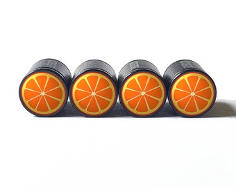 May include: Four black valve stem caps with orange and yellow printed images of orange slices.