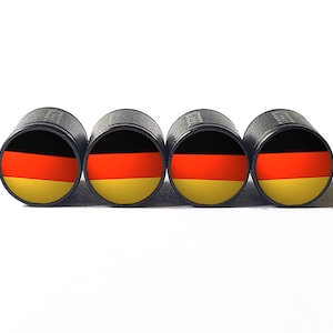 May include: Four black valve stem caps with the German flag printed on them. The flag is black, red, and yellow.