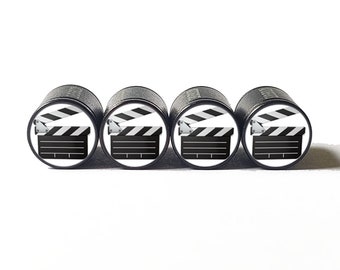 May include: Set of four black valve stem caps with a white background and a black and white clapperboard design.