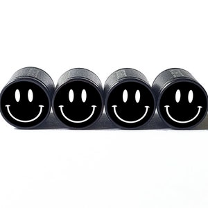 May include: Four black valve stem caps with white smiley faces.