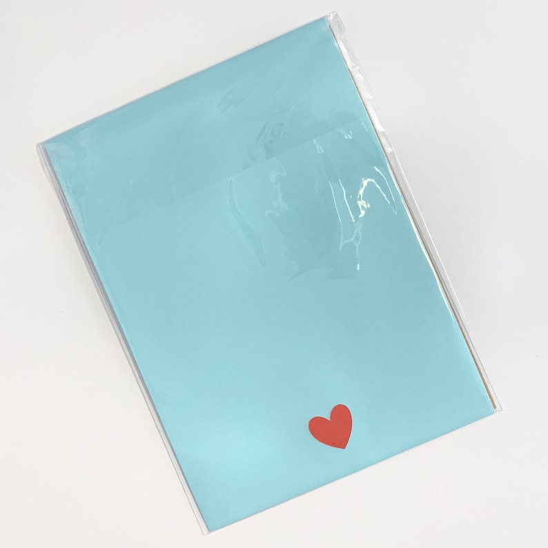 May include: A light blue card with a red heart in the bottom right corner.