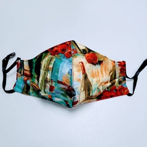 May include: A reusable face mask with a colorful abstract print featuring wine bottles and grapes. The mask has black elastic ear loops.