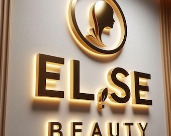 May include: Gold-colored illuminated sign for "ELSE BEAUTY" with a woman's profile in a gold circle above the text. The word "BEAUTY" is below the other text. The sign is mounted on a light-colored wall.