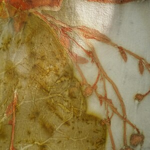 May include: A textile piece featuring botanical prints with earthy olive green and rust orange tones. The fabric displays intricate leaf vein patterns and delicate branch silhouettes with small buds. The text Florich Studio is visible.