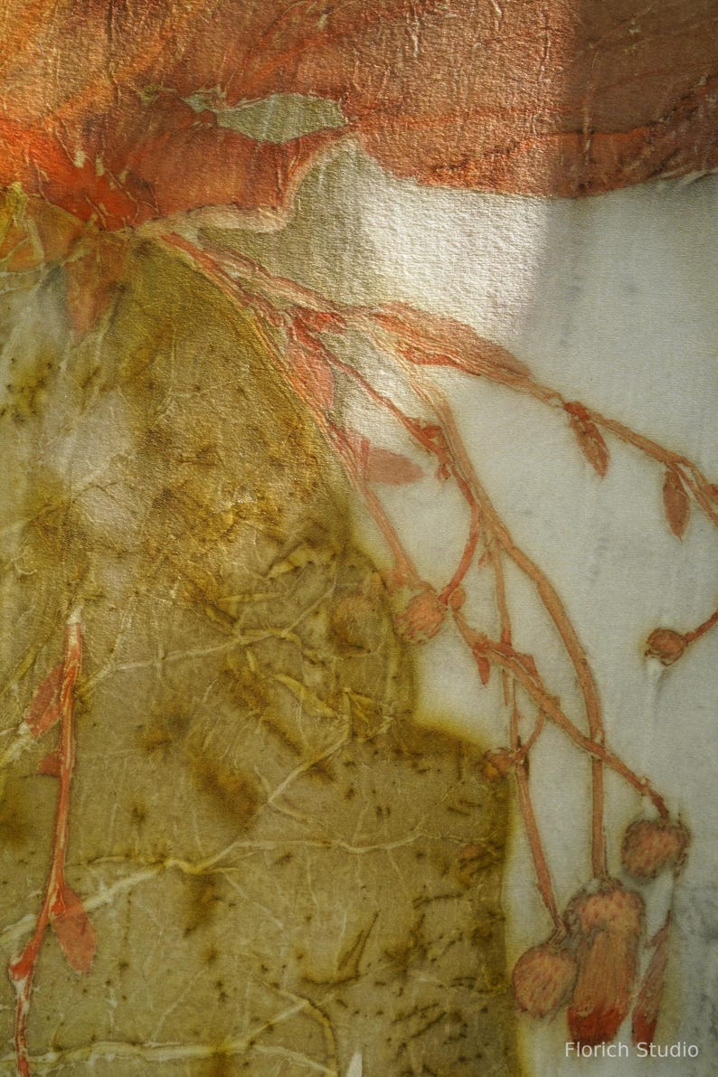 May include: A textile piece featuring botanical prints with earthy olive green and rust orange tones. The fabric displays intricate leaf vein patterns and delicate branch silhouettes with small buds. The text Florich Studio is visible.