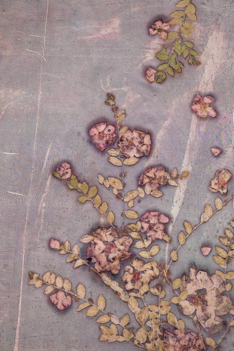 May include: A botanical print featuring pressed flowers and leaves in shades of pink, beige, and green against a muted blue-gray background. The floral arrangement includes detailed blooms and delicate foliage, creating a vintage aesthetic.