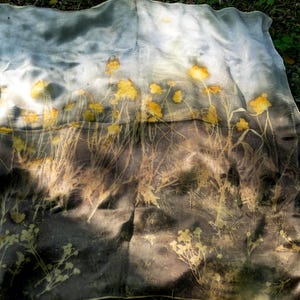 May include: A rectangular fabric piece featuring a botanical print with yellow flower silhouettes against a gradient background that transitions from a light grey at the top to a dark charcoal grey at the bottom, displaying organic plant stems.
