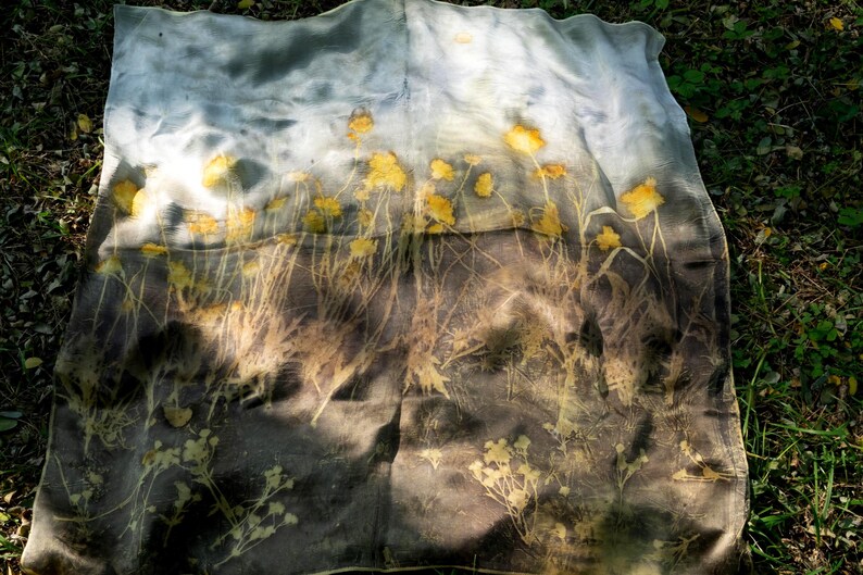 May include: A rectangular fabric piece featuring a botanical print with yellow flower silhouettes against a gradient background that transitions from a light grey at the top to a dark charcoal grey at the bottom, displaying organic plant stems.