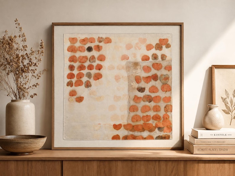 May include: A square framed wall art piece featuring a textile with a grid-like pattern of pressed orange and brown leaves. The fabric is off-white, and the leaves are arranged in rows, creating a botanical print effect within a wooden frame.