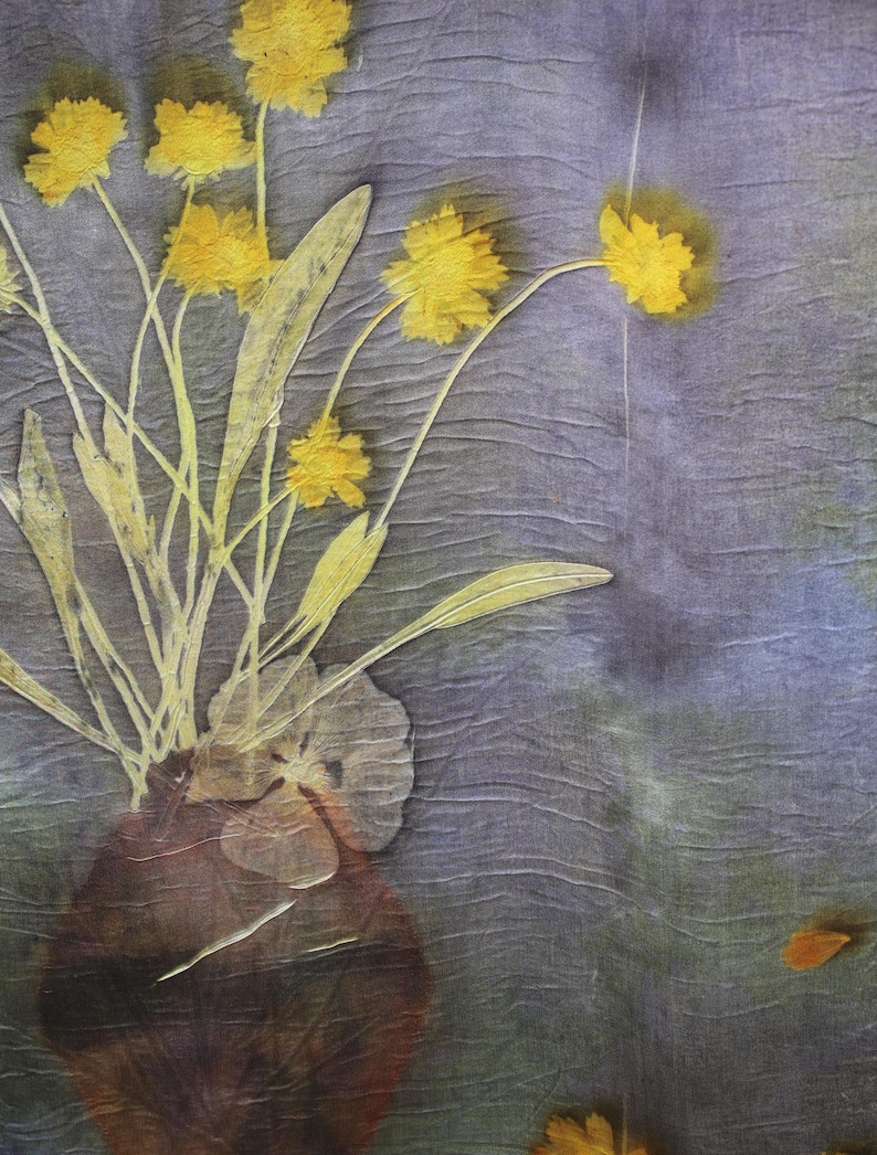 May include: A textile piece featuring a botanical print of yellow flowers in a dark brown vase against a textured, muted purple and green background. The design displays delicate stems, leaves, and flower heads with a visible fabric grain.