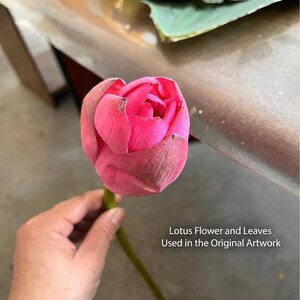 May include: A vibrant pink lotus flower bud with a long green stem, featuring layered petals with subtle texture. The text "Lotus Flower and Leaves Used in the Original Artwork" is printed in white on the right side of the image.