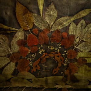 May include: A textile piece featuring a botanical print with dark brown and black background tones. The design displays an arrangement of pressed leaves in shades of olive green, golden yellow, and deep rust red, creating a layered floral pattern.