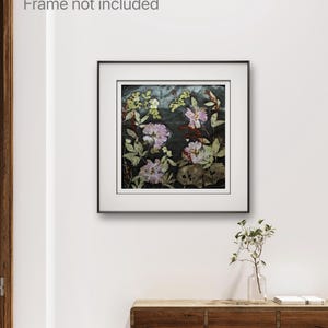 May include: A square wall art print featuring pressed flowers in shades of pink, white, and green against a dark, textured background. The artwork is displayed within a thin black frame with a white mat border. The text Frame not included is visible.