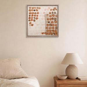 K&ouml;nnte beinhalten: Ein quadratisches Wandbild mit einem Raster aus gepressten, getrockneten braunen Bl&auml;ttern, die in einem Muster auf hellem Hintergrund angeordnet sind, eingefasst in einen d&uuml;nnen, verwitterten Holzrahmen. Die Komposition enth&auml;lt ein texturiertes Rechteck.