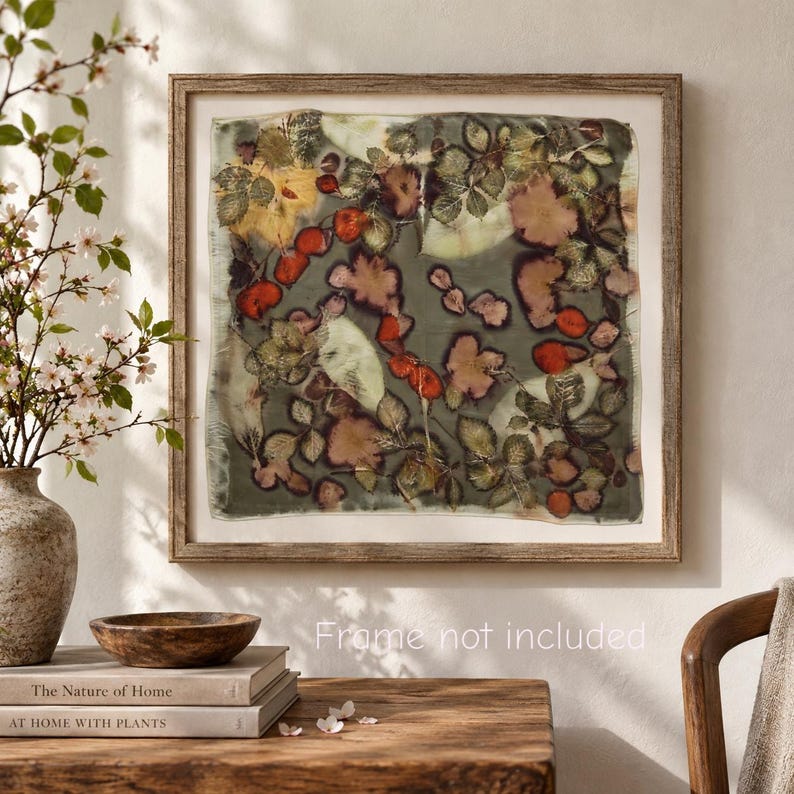 May include: A square textile wall art piece featuring a botanical print with pressed leaves and flowers in shades of green, red, and brown on a muted background. The artwork is displayed within a wooden frame, and the text Frame not included is visible.