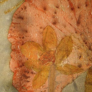 May include: A textile art piece featuring a large, mottled peach-colored leaf shape layered over a translucent gray background. A cluster of smaller, golden-brown leaves is centered on the peach leaf. The text Florich Studio appears at the bottom.