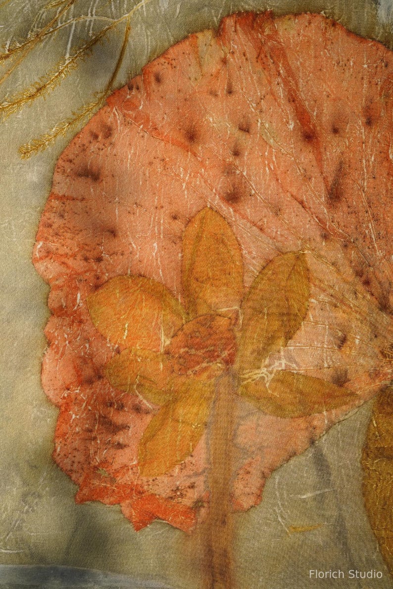 May include: A textile art piece featuring a large, mottled peach-colored leaf shape layered over a translucent gray background. A cluster of smaller, golden-brown leaves is centered on the peach leaf. The text Florich Studio appears at the bottom.