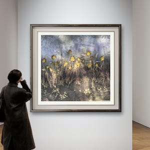 May include: A square wall art print featuring a botanical composition of yellow wildflowers against a dark, textured blue and grey background. The artwork is displayed within a dark brown frame and includes the text Frame not included.