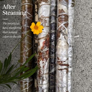May include: Several cylindrical bundles of silk wrapped in clear plastic and tied with string, containing botanical elements. Text reads: After Steaming. The botanicals have transferred their natural colors to the silk. A bright yellow flower is visible.