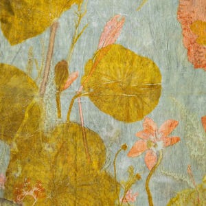 May include: A botanical print on textured paper featuring pressed yellow and orange leaves and flowers against a pale blue-grey background. The composition includes various circular foliage and delicate stems. The text Florich Studio is visible.