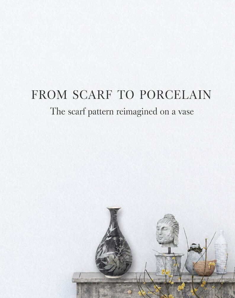 May include: A black and white porcelain vase with a botanical pattern, positioned next to a stone Buddha head sculpture, a small grey vessel, and a tall white textured vase. The text reads: FROM SCARF TO PORCELAIN. The scarf pattern reimagined on a vase.