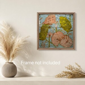 May include: A square wall art piece featuring pressed botanical elements in shades of green and muted pink against a light blue background, enclosed in a thin wooden frame. The artwork displays organic leaf and flower shapes with visible textures.