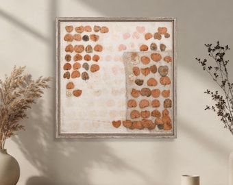 Puede incluir: Una pieza de arte mural cuadrada que presenta una cuadrícula de hojas secas y prensadas en tonos naranja, marrón y crema. Las hojas están dispuestas en un patrón estructurado sobre un fondo claro, enmarcadas por un borde fino de madera clara.