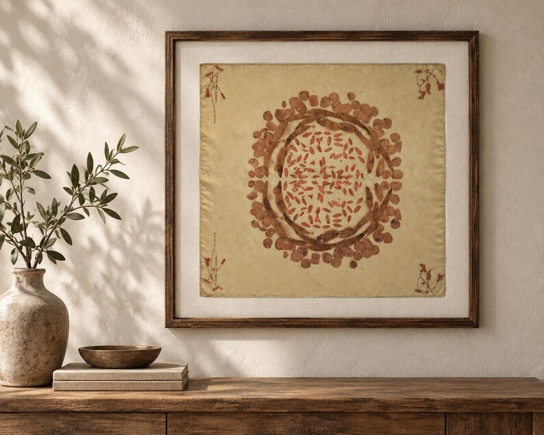 Pu&ograve; includere: Un'opera d'arte da parete quadrata incorniciata con uno sfondo in tessuto beige chiaro e una stampa botanica circolare centrale. Il design &egrave; composto da foglie e baccelli bruno-rossastri disposti in modo simmetrico, con piccoli rametti negli angoli.