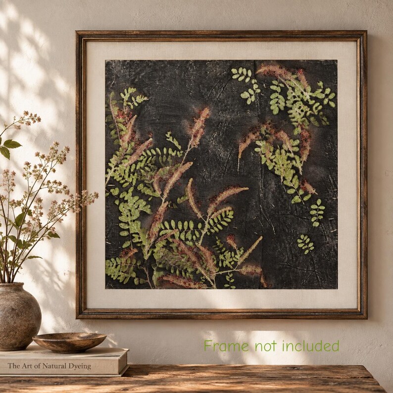 May include: A square wall art print featuring a dark, textured charcoal background with pressed green and reddish-brown fern-like foliage. The artwork is encased in a thin, dark brown wooden frame with a light-colored mat border.