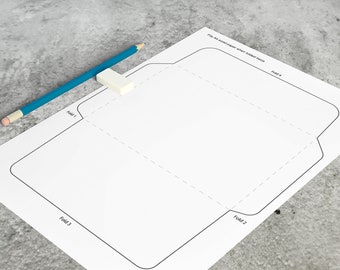 May include: A white sheet of paper with a printed envelope template featuring dashed fold lines labeled Fold 1, Fold 2, Fold 3, and Fold 4, along with the text "Fits A4 sized paper when folded twice." A blue pencil and a white eraser rest on the paper.