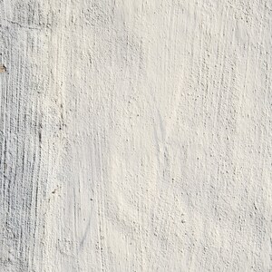 Puede incluir: Primer plano de una pared blanca texturizada con sutiles líneas verticales. La pared tiene una superficie ligeramente rugosa y desigual.