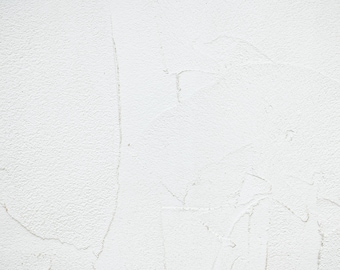May include: A white textured wall with subtle imperfections and faint lines.