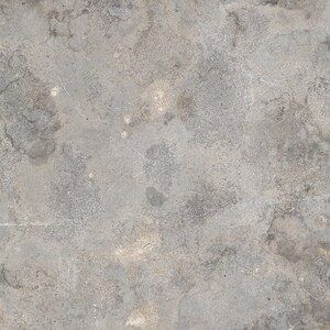Puede incluir: Primer plano de una superficie de hormigón gris con textura rugosa. La superficie tiene un aspecto moteado con áreas grises más claras y más oscuras.
