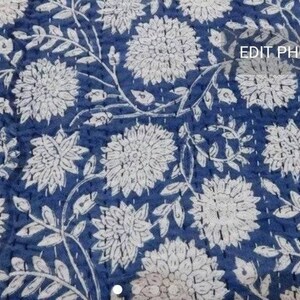 Pu&ograve; includere: Un tessuto blu con un motivo floreale bianco. Il tessuto ha una texture trapuntata.