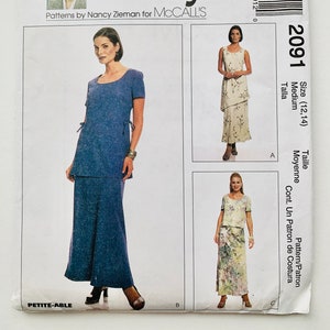 Puede incluir: Patrón de costura para un vestido y una falda, talla 12-14, de Nancy Zieman para McCall's. El patrón incluye una falda con un detalle de lazo y un vestido con una falda de capas.