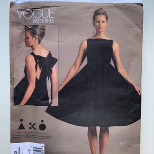 May include: Vogue Patterns sewing pattern for a black sleeveless dress with a bow detail in the back. The pattern number is V1102 and the size is AA (6-8-10-12). The pattern is designed by Andre Katz Objects.
