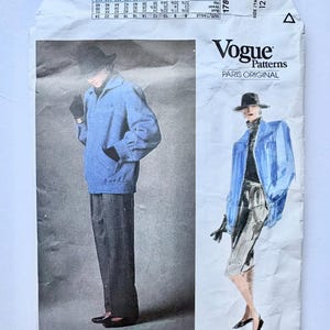 Pode incluir: Um padrão de costura vintage da Vogue Patterns com um design Givenchy. O pacote do padrão mostra um conjunto de jaqueta e calças azuis. O texto "Vogue Patterns Paris Original" e "1787" são visíveis.