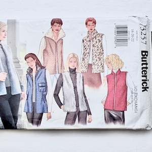 May include: A Butterick 3257 sewing pattern envelope featuring illustrations of five different vest styles. The designs include a long grey vest, a tan vest with a wide collar, a blue vest with pockets, a white faux fur vest, and a red quilted vest.