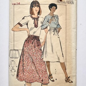 May include: A Butterick sewing pattern envelope, size 14, featuring illustrations of two outfits. One shows a short-sleeved top with a tie-neck and a floral print skirt. The other shows a striped long-sleeved top with a solid skirt. Text includes Butterick 5523.