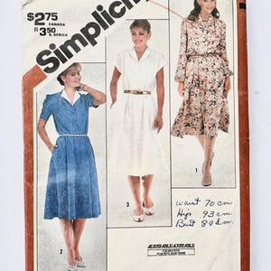 May include: Vintage Simplicity sewing pattern featuring three dress designs. The pattern includes measurements in centimeters: waist 70 cm, hips 93 cm, and bust 89 cm. The cover has the text "OVERNIGHT SUCCESS" and "SUCCES DU JOUR AU LENDEMAIN".