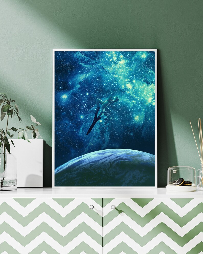 May include: A digital art print featuring a silhouette of a person diving into a starry night sky above a blue planet. The print has a blue, white, and black color scheme.