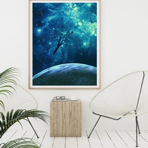 May include: A framed print of a woman diving into a blue and green galaxy with stars and a planet in the background.