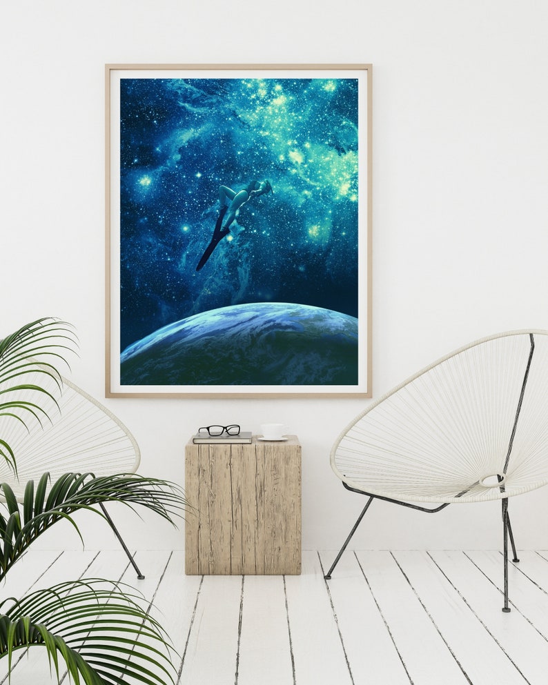 May include: A framed print of a woman diving into a blue and green galaxy with stars and a planet in the background.