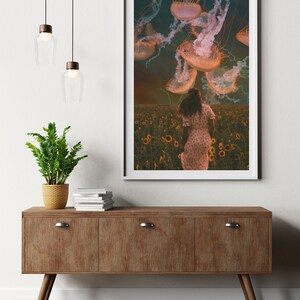 May include: A woman in a white dress walks through a field of sunflowers, looking up at a sky filled with jellyfish.