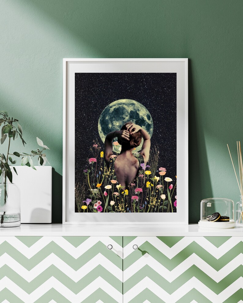 May include: A woman stands in a field of flowers, looking up at a full moon in a starry night sky. The woman's back is to the viewer, and her arms are raised above her head. The moon is a pale green color, and the stars are white.