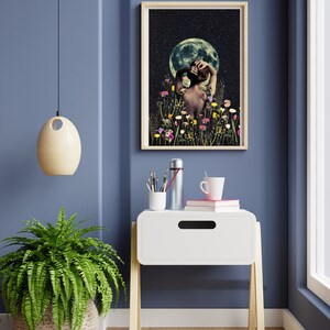 May include: A framed print of a woman standing in a field of flowers with a full moon in the background. The woman is facing away from the viewer and has her hair pulled back. The moon is a light blue color and the flowers are a variety of colors.