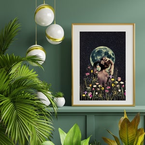 May include: A gold framed print with a woman standing in a field of flowers with a full moon and stars in the background.