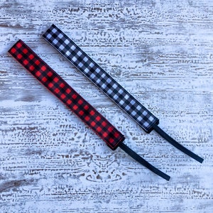 May include: Two black and white gingham ribbon hair ties with black elastic. One hair tie is red and black gingham.