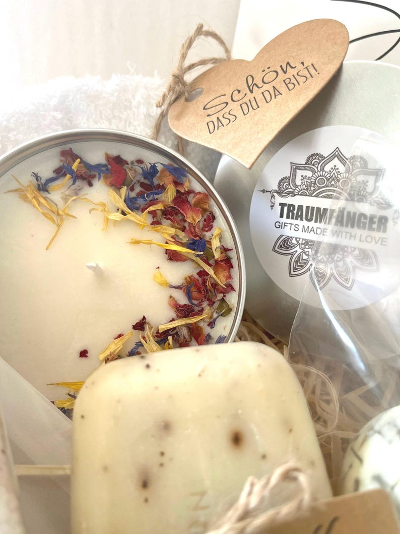 May include: A gift basket with a white candle with dried flower petals, a bar of soap, a small tin with a mandala design and the text "Traumf&auml;nger Gifts Made With Love", and a heart-shaped tag with the text "Sch&ouml;n, dass du da bist!"