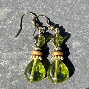 May include: A pair of green glass drop earrings with gold-toned beads and hooks.